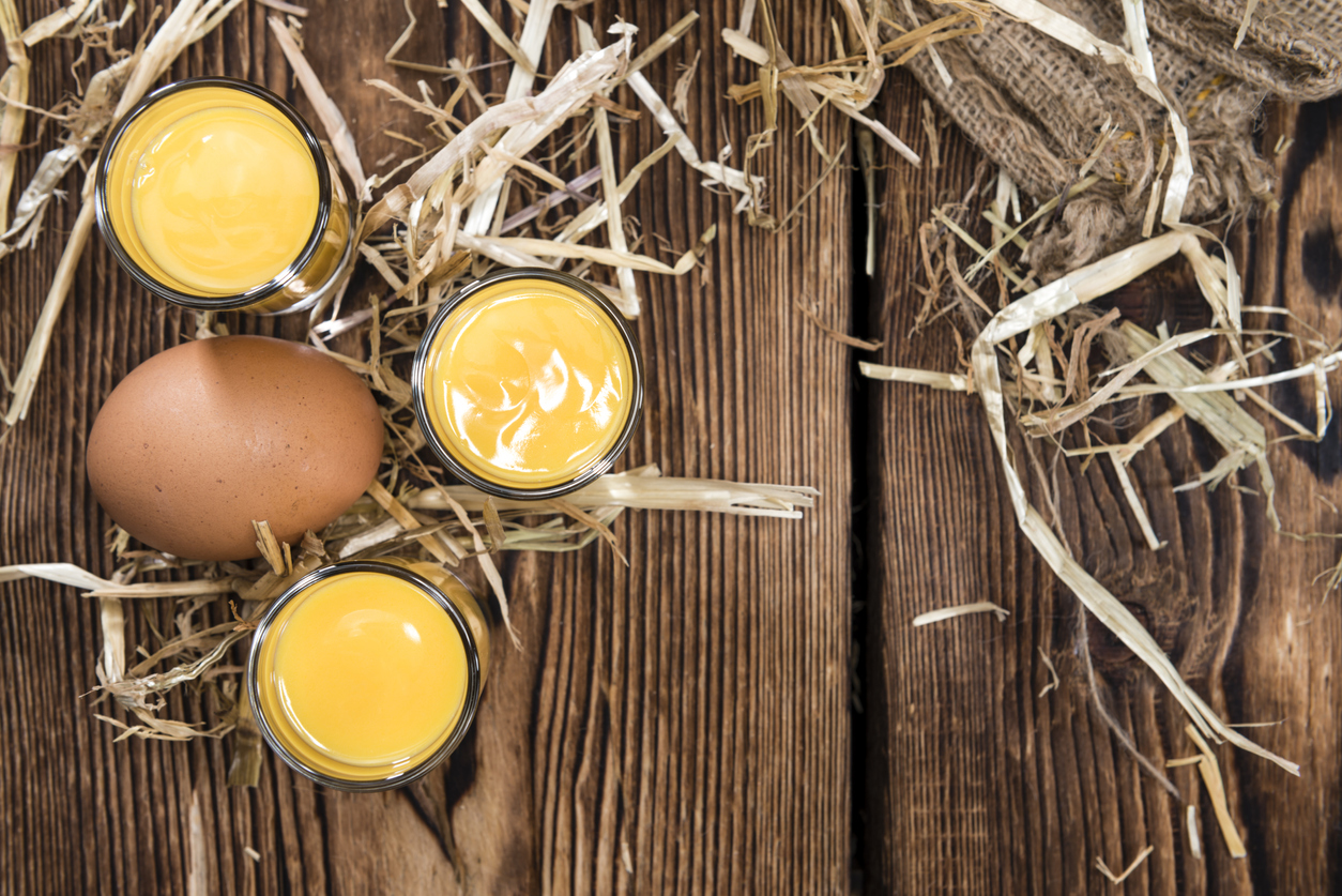 Egg Liqueur (close-up shot) on wooden background